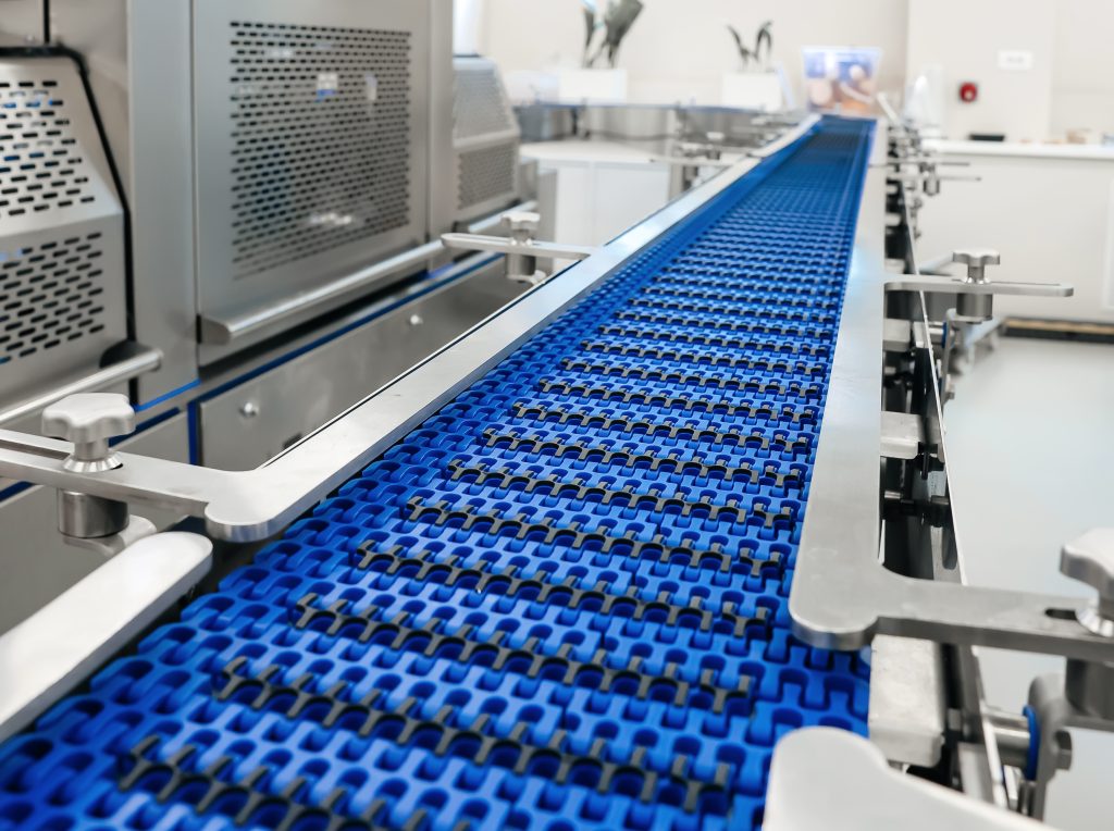 traysealer carousel conveyer for running trials packing products inside machine Processing of Packaging equipment industrial factory. Packing food in production line. Vacuum machine